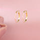 Strahlende goldene Ohrringe mit rosa und lila Epoxidharz