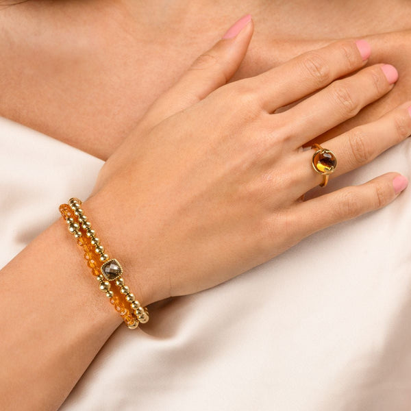 Elastische Kralenarmband met Amber en Gouden Kralen - Goudkleurig & Oranje