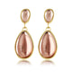 Elegante goldene Ohrringe mit rosa Tropfenstein