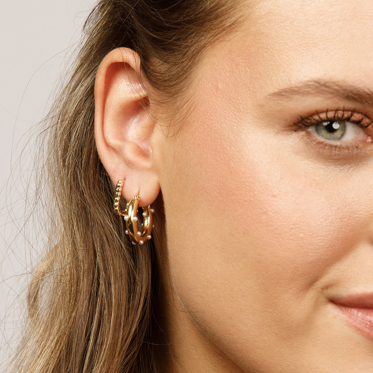 Elegant gold earring with radiant pearls