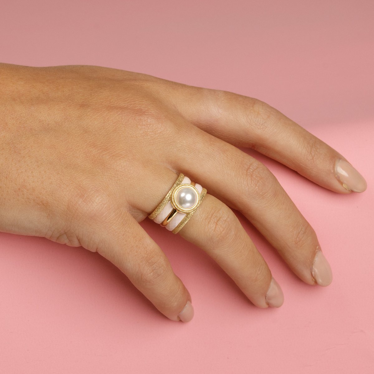Elegante gouden ringenset met witte parel, stardust en roze keramiek. 5 ringen, los te dragen. 1 jaar garantie.