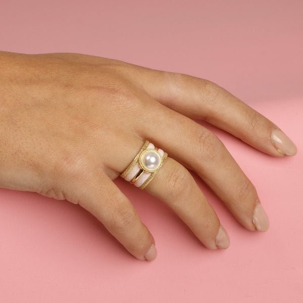 Elegante gouden ringenset met witte parel, stardust en roze keramiek. 5 ringen, los te dragen. 1 jaar garantie.
