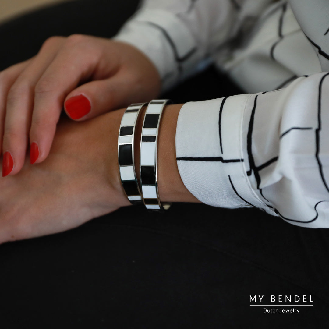 Elegante zilveren bangle van 10 mm met zwart-wit epoxy. Blijft jarenlang mooi, irriteert niet en verkleurt niet. Perfect voor elke gelegenheid. # MB1001